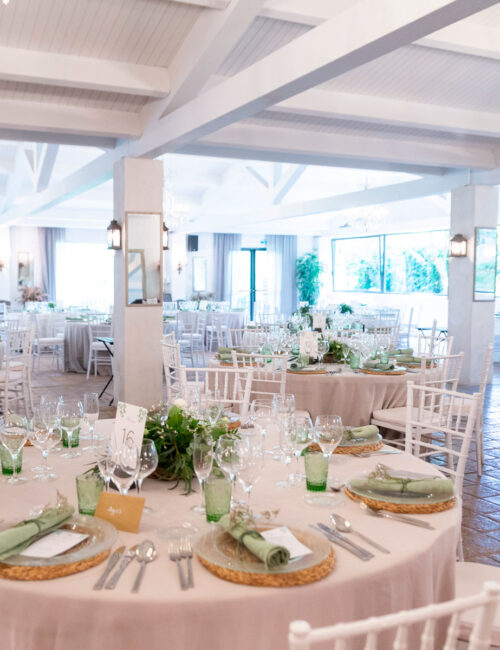 Amplio y luminoso salón comedor con grandes ventanales y mesas colocadas para una celebración